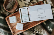 Fresh Wife bath bomb set on wooden tray with herbal tea bags and cozy blanket background