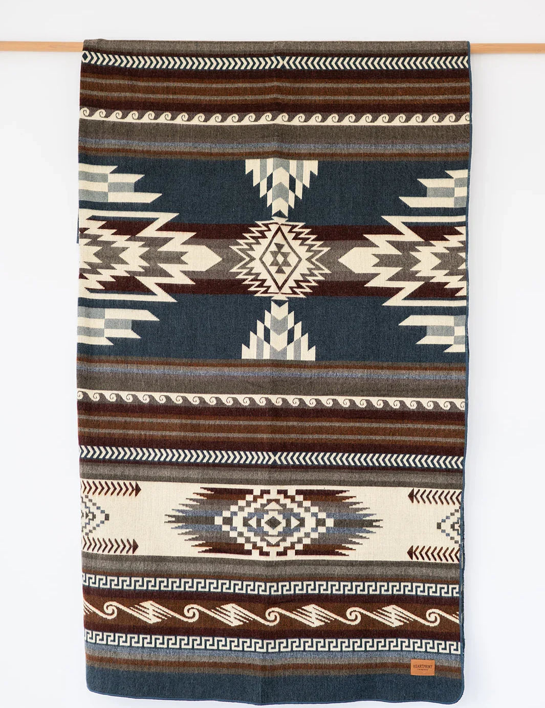 Woven Queen Blanket hanging on white background, country living