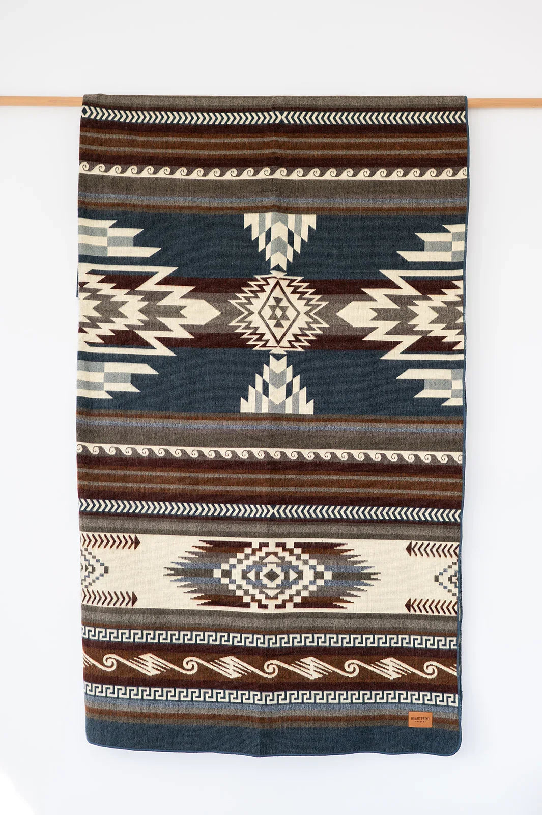 Woven Queen Blanket hanging on white background, country living