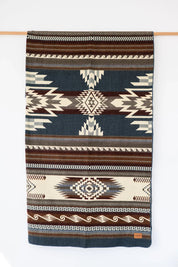 Woven Queen Blanket hanging on white background, country living
