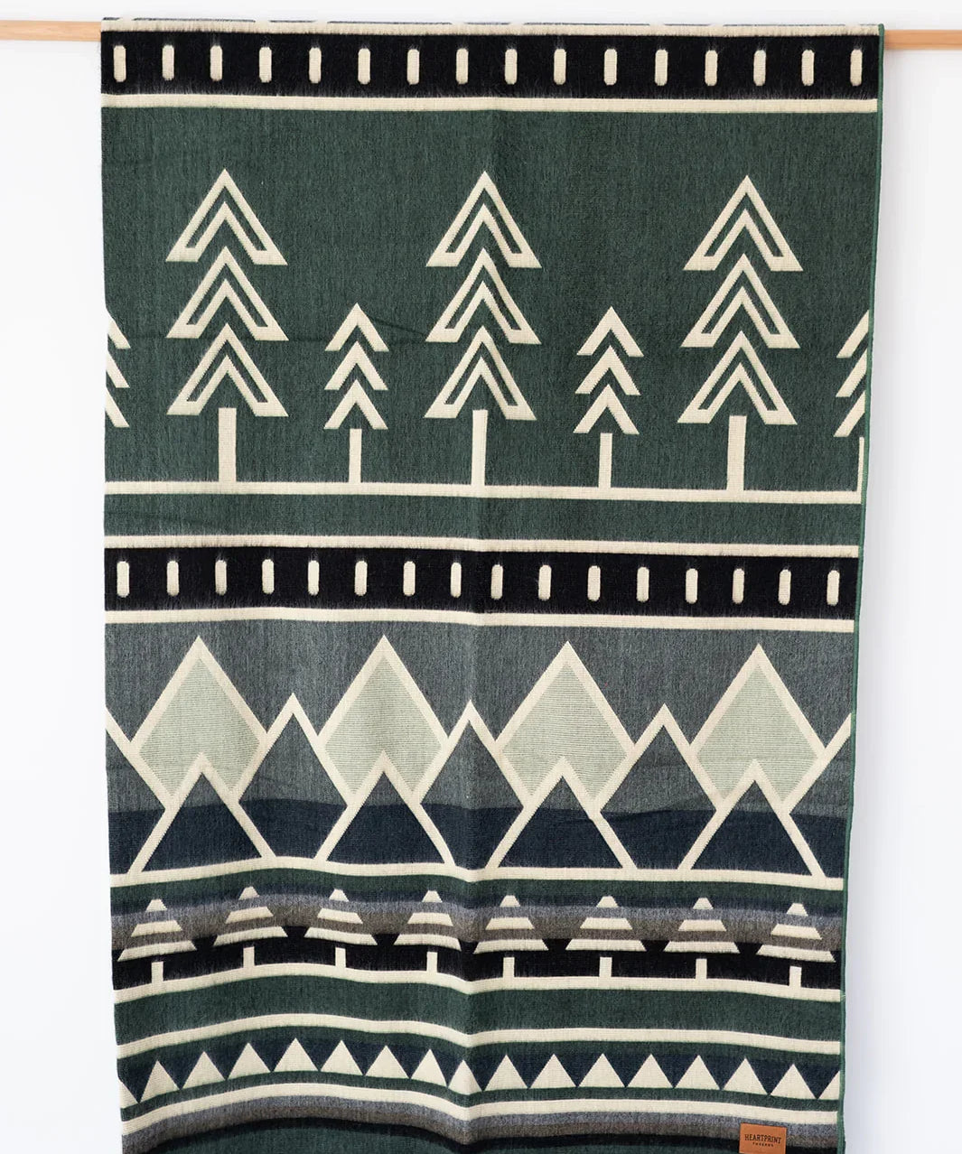 Woven Blanket Blues Mountain and Tree Design Hanging on white background
