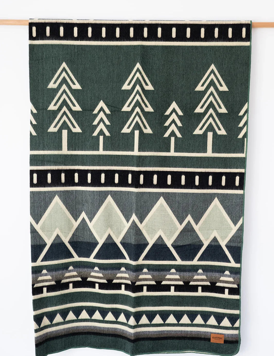 Woven Blanket Blues Mountain and Tree Design Hanging on white background