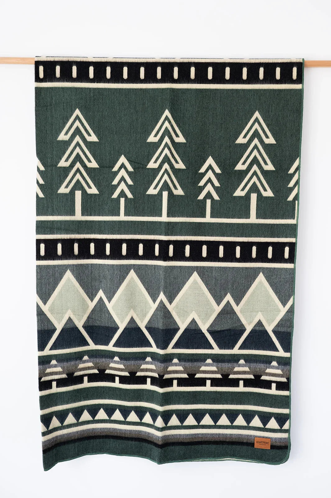 Woven Blanket Blues Mountain and Tree Design Hanging on white background