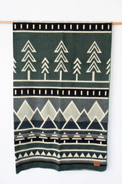 Woven Blanket Blues Mountain and Tree Design Hanging on white background