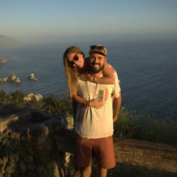 Smiling couple enjoying coastal ocean view at sunset, summer travel adventure scene